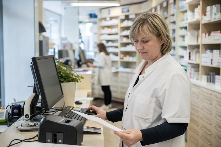 Apothekenmitarbeiter prüft Unterlagen für einen Retaxationseinspruch